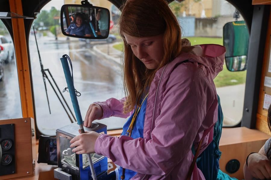 High school student paying bus fare to ride the public transportation bus. She is holding her cane in one hand and paying. High school student paying bus fare to ride the public transportation bus. She is holding her cane in one hand and paying.